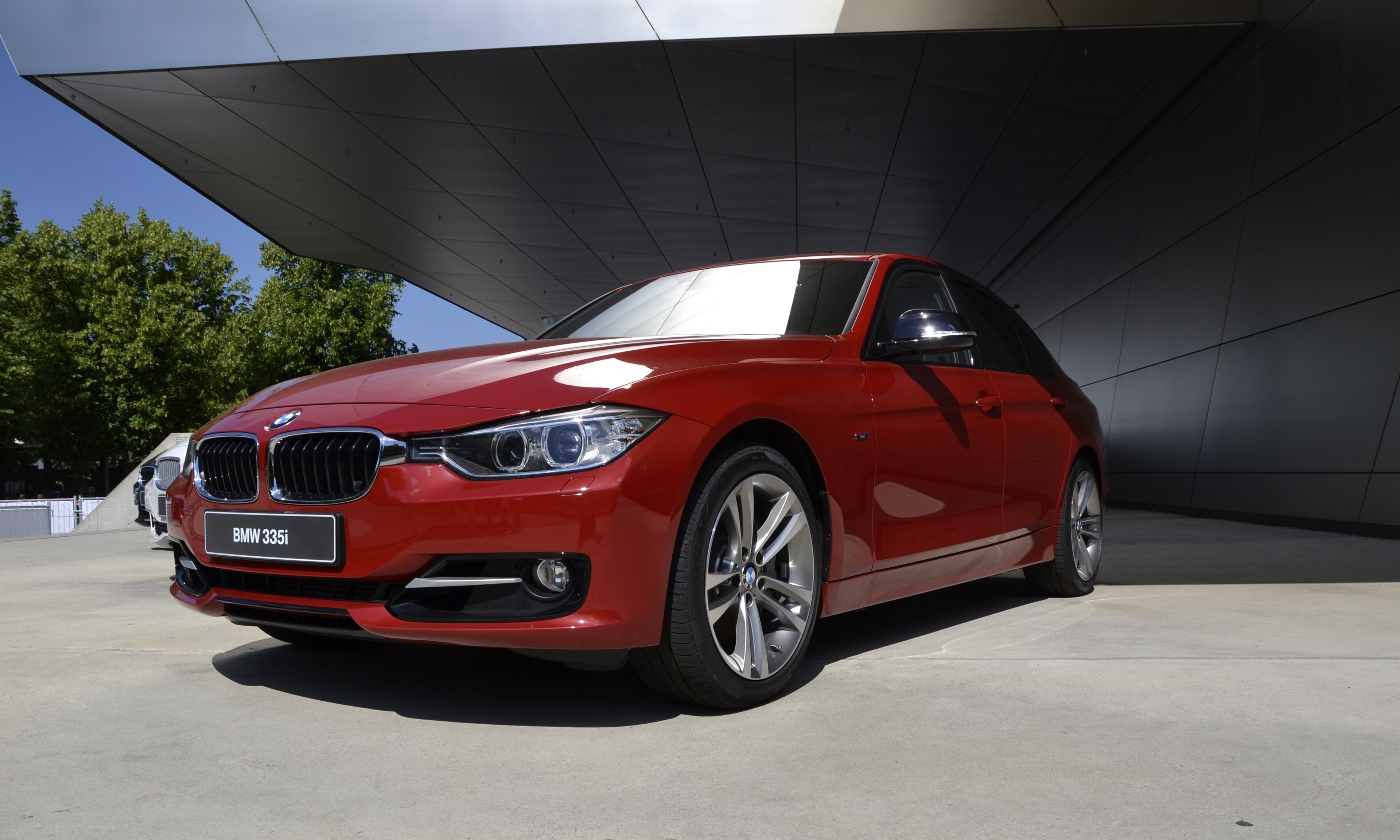 Красный седан BMW 335i поколения F30 у BMW Welt в Мюнхене